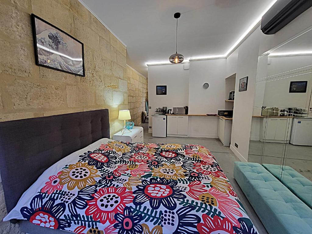- une chambre avec un lit et une couverture colorée dans l'établissement Appartement cosy avec jardin terrasse et bureau séparé, à Bordeaux