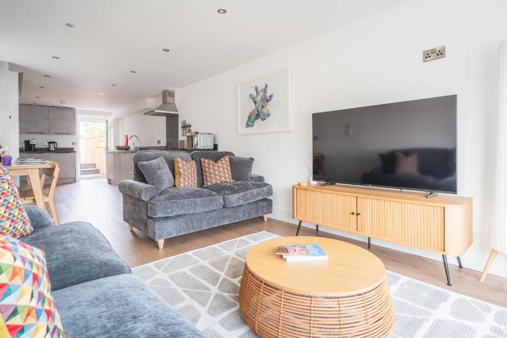 Una sala de estar con dos sofás y un televisor de pantalla plana. en Hoheck, en Pwllheli