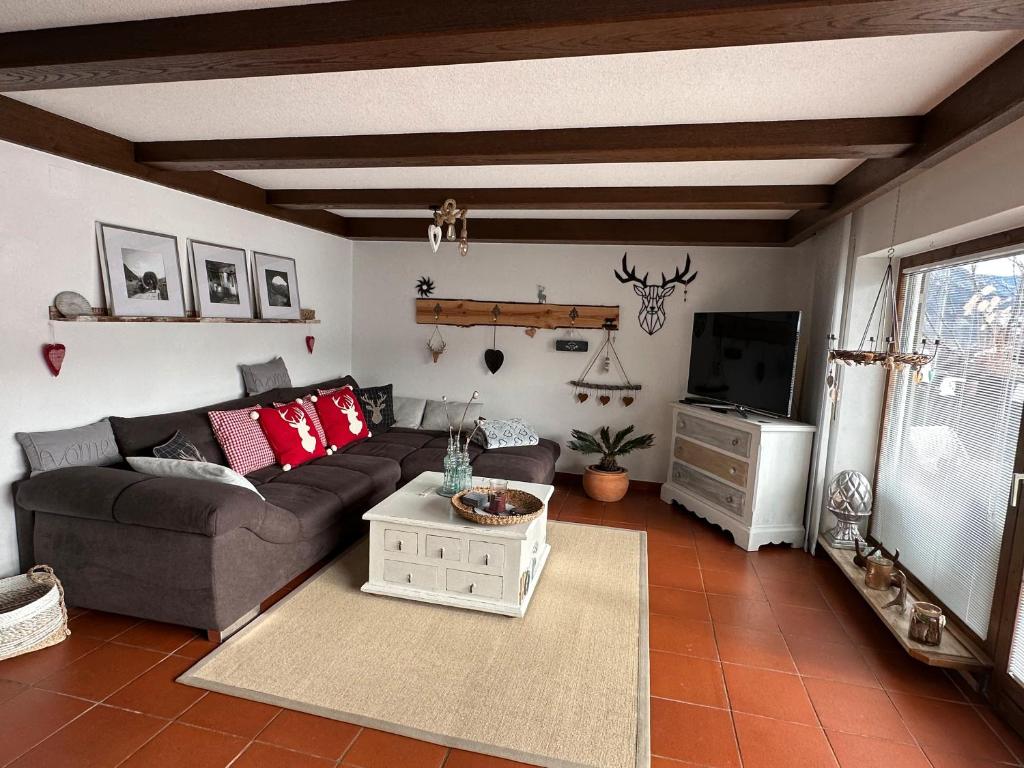 a living room with a couch and a tv at Ferienwohnung Alpenherz 80qm in Blaichach