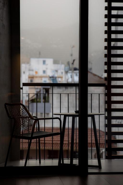 a table and a chair sitting on a balcony at Magnes Hotel in Volos