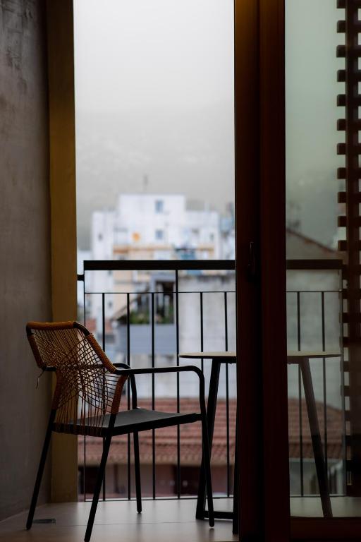 a chair and a table in front of a window at Magnes Hotel in Volos