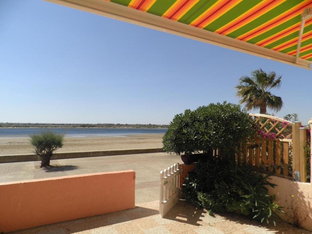 - une vue sur la plage depuis la terrasse couverte d'une maison de plage dans l'établissement Maison 4 pièces - Gruissan GN500-014, à Gruissan
