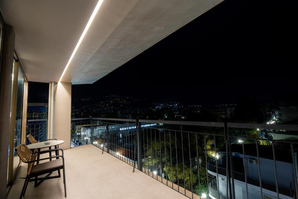 a balcony with a view of the city at night at Magnes Hotel in Volos