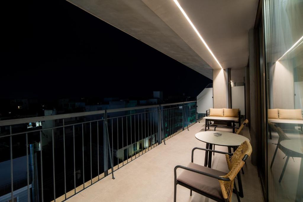 a balcony with chairs and a table on a building at Magnes Hotel in Volos