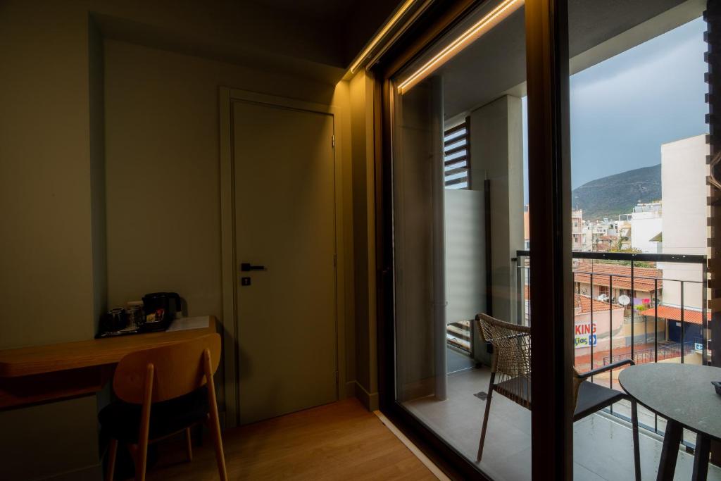 a room with a view of a balcony with a table and chairs at Magnes Hotel in Volos