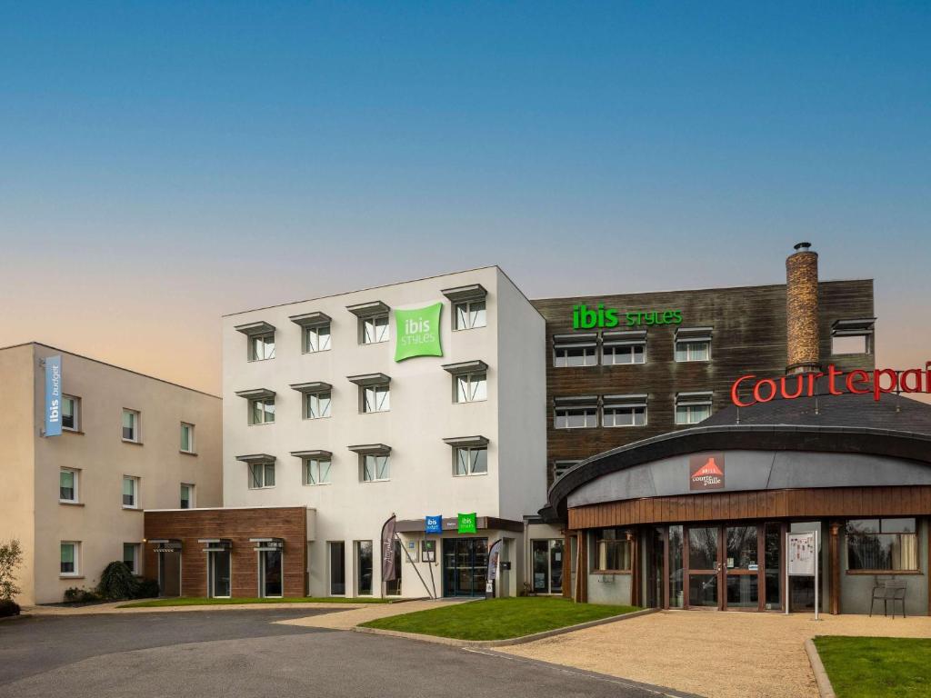 un grand bâtiment avec une cour dans l'établissement ibis Styles Pontivy centre Bretagne, à Pontivy