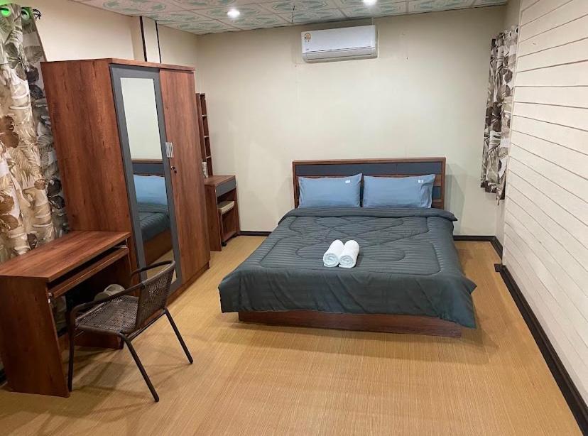 a bedroom with a bed with two white towels on it at Ban Pak Khun Taa in Khon Kaen
