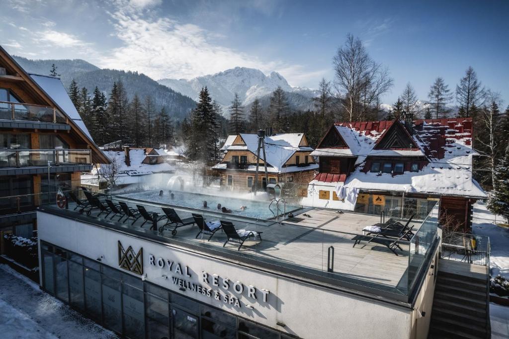 a resort with a swimming pool in the snow at VisitZakopane - Royal Resort Wellness & SPA in Zakopane