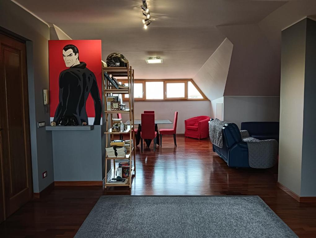 a living room with a painting of a man on the wall at Mansarda Open Space in Ciampino