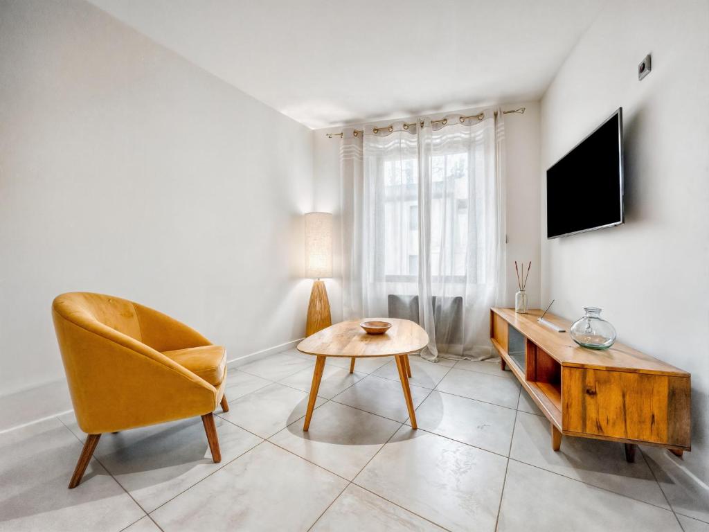 un salon avec une chaise et une table dans l'établissement Charmant T3 avec climatisation proche Narbonne, à Cuxac-dʼAude