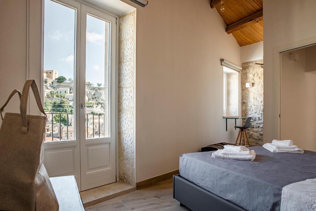 ein Schlafzimmer mit einem Bett und einem großen Fenster in der Unterkunft Casa Teresa con vista in Modica