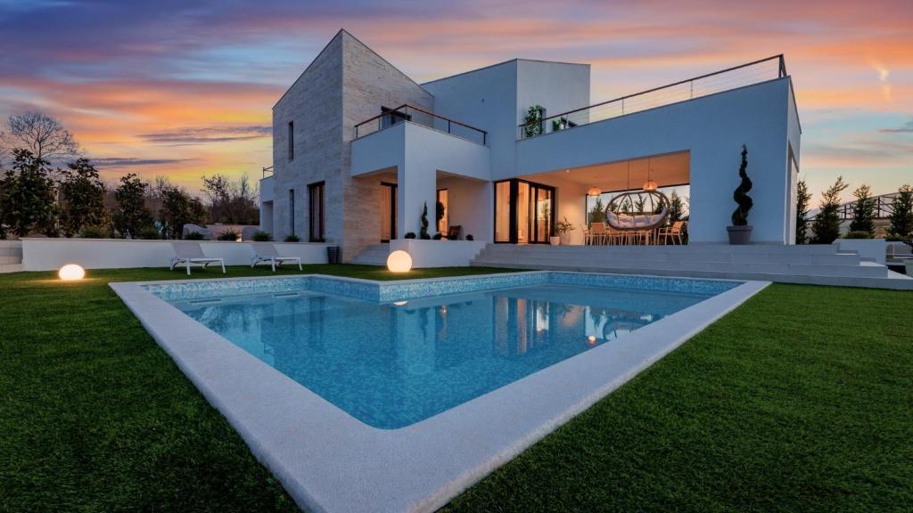 a house with a swimming pool in front of it at Casa Lei by Villas Holiday in Malinska
