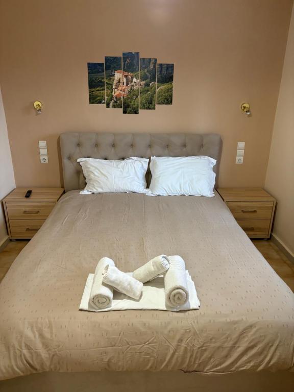 Una cama con dos toallas y dos fotos. en Paradise of Meteora B, en Kastraki