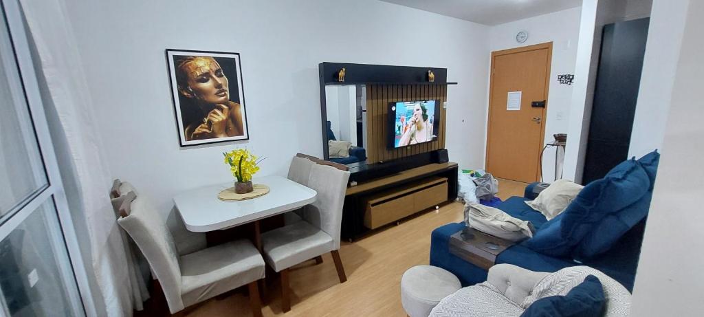a living room with a tv and a table and a couch at Apto completo proximo arena pantanal in Cuiabá