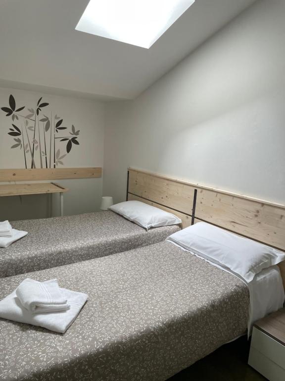 two beds in a room with two white towels at Low Cost Ferrara in Ferrara