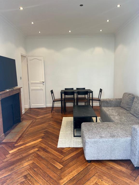 a living room with a couch and a table at Magnifique appartement 2 chambres Paris 16e Trocadéro Tour Eiffel in Paris