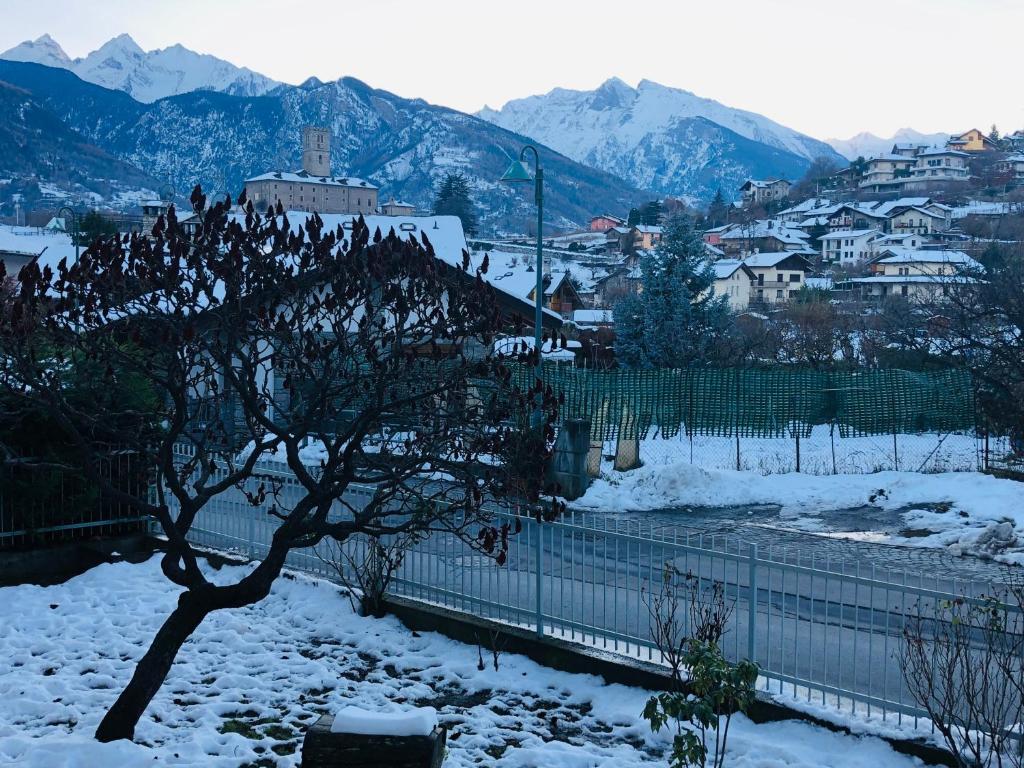 Una ciudad cubierta de nieve con montañas al fondo en Maison du Château Sarre, en Aosta