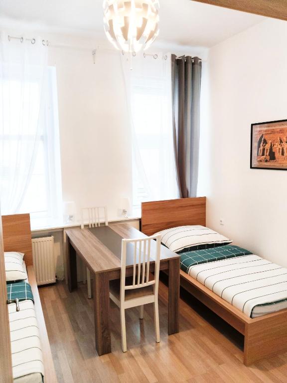 维也纳Favorit-Rooms Direkt Metro-U1 best connection to Centralstation and City-Center的一间带桌子和桌椅的用餐室