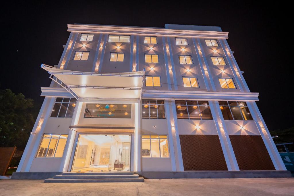 a tall building with lights on it at night at Lotus Leaf in Pali