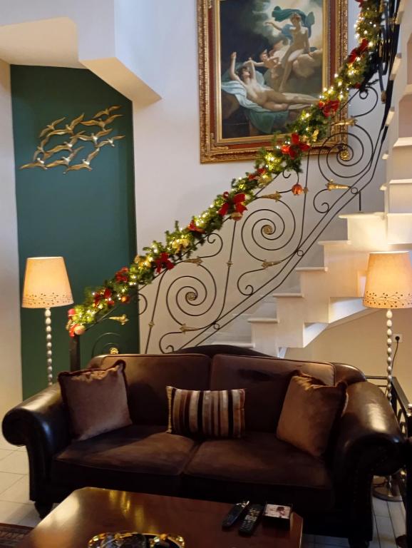 a living room with a couch and a staircase with christmas lights at Three Goods Trikala Meteora in Tríkala