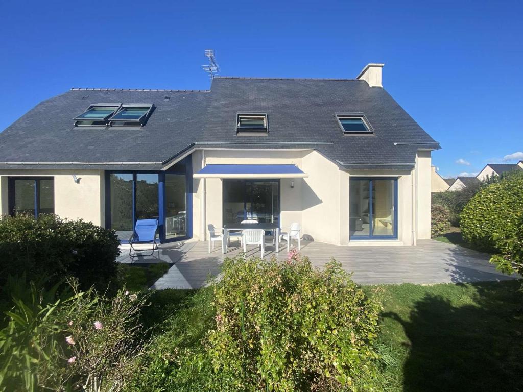 une maison avec une terrasse avec une table et des chaises dans l'établissement Maison lumineuse 3 étoiles, proche plages, 4 chambres, terrasse et jardin à Beg-Meil - FR-1-481-84, à Fouesnant