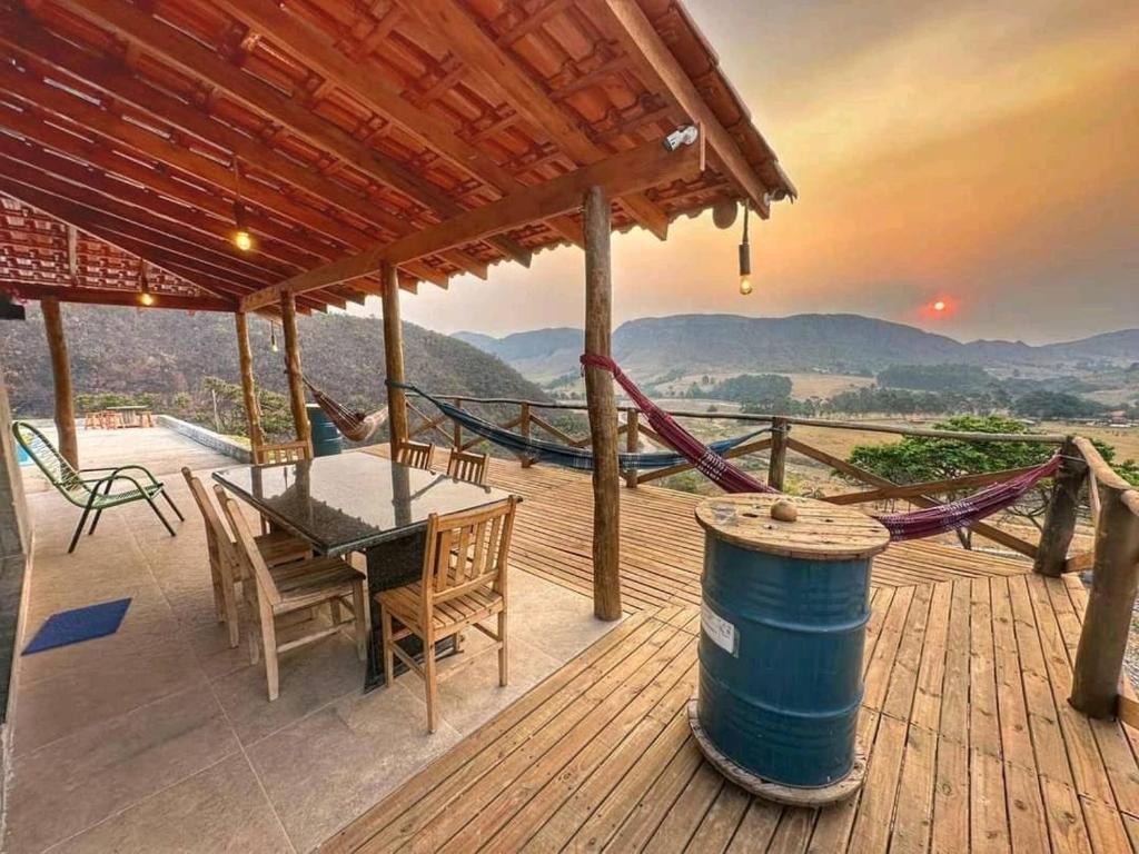 a wooden deck with a table and a hammock at Estância Hidromineral Serra da Canastra - Delfinópolis MG in Delfinópolis