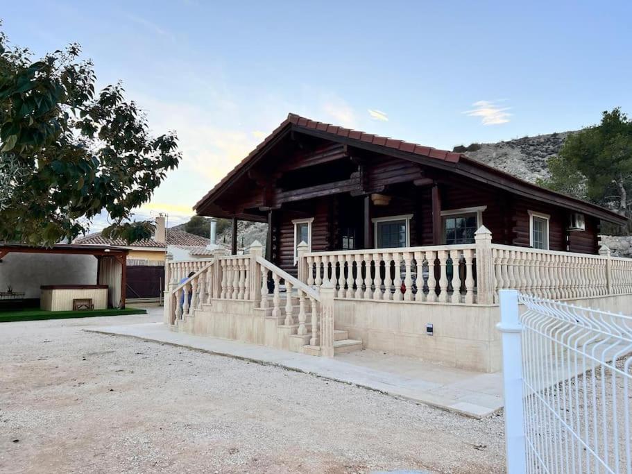 a house with a white fence in front of it at La casica de madera con Jacuzzi exterior y barbacoa in Murcia