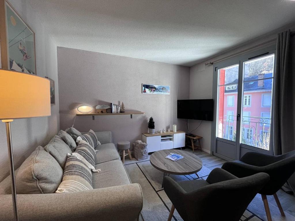 un salon avec un canapé et une table dans l'établissement Duplex charmant à Cauterets, proche commerces et téléphérique - FR-1-812-82, à Cauterets