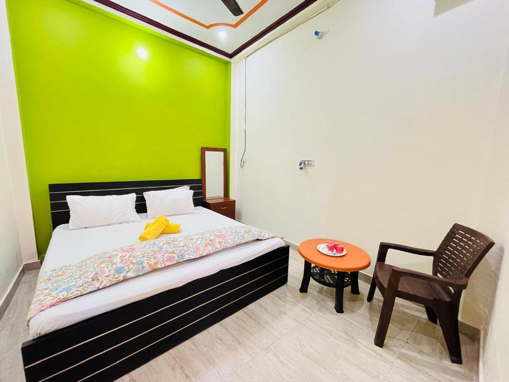 a bedroom with a green wall and a bed and a table at Om Home Stay 3BHK in Ayodhya