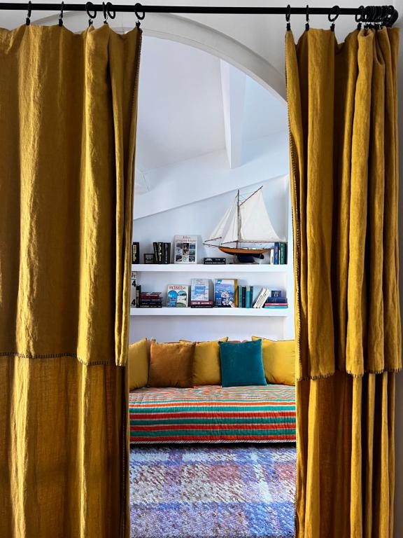 a couch sitting in a living room with curtains at LE ZOLA Appartement solaire in La Ciotat