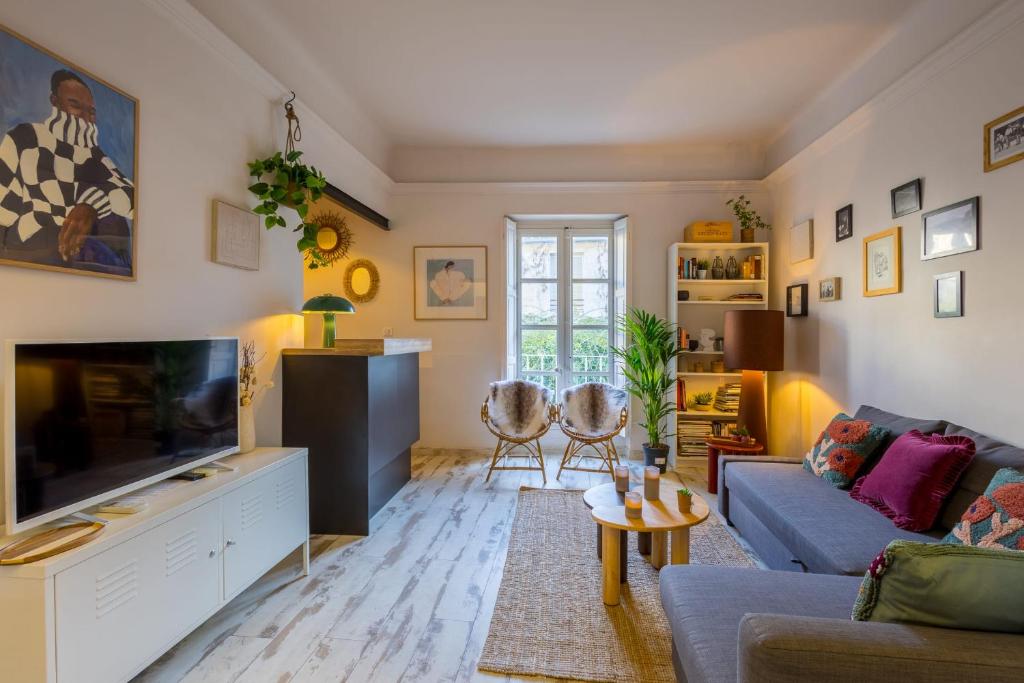 un salon avec un canapé et une télévision dans l'établissement Appartement Limpero - Welkeys, à Avignon