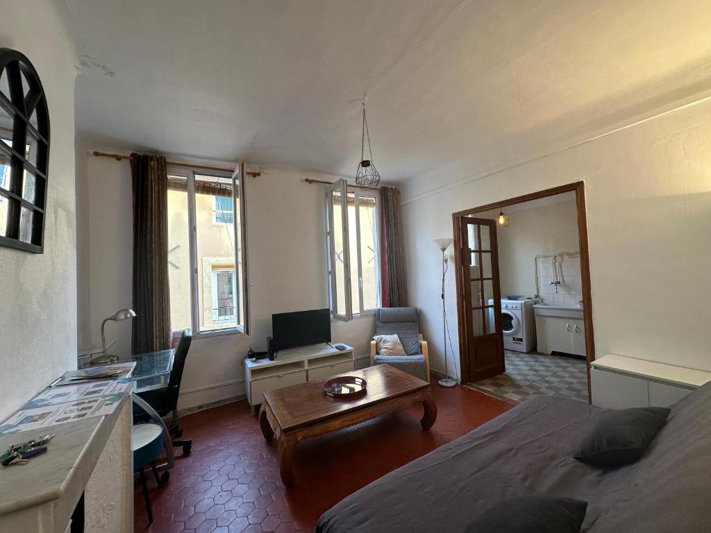 Cet appartement comprend une chambre avec un lit et un salon avec une table. dans l'établissement Chez Monique - Appartement T2 au cœur du centre ville historique - proche Mairie et Cardeurs, à Aix-en-Provence