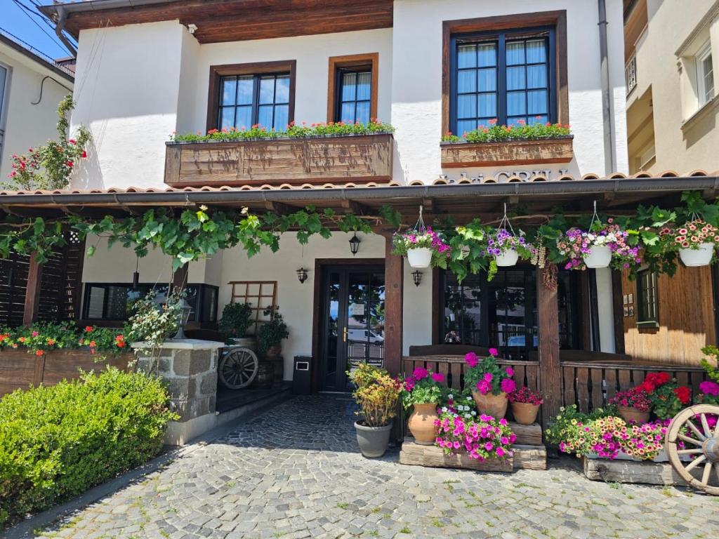un edificio con macetas y flores. en Bujtina Jaki, en Gjakove