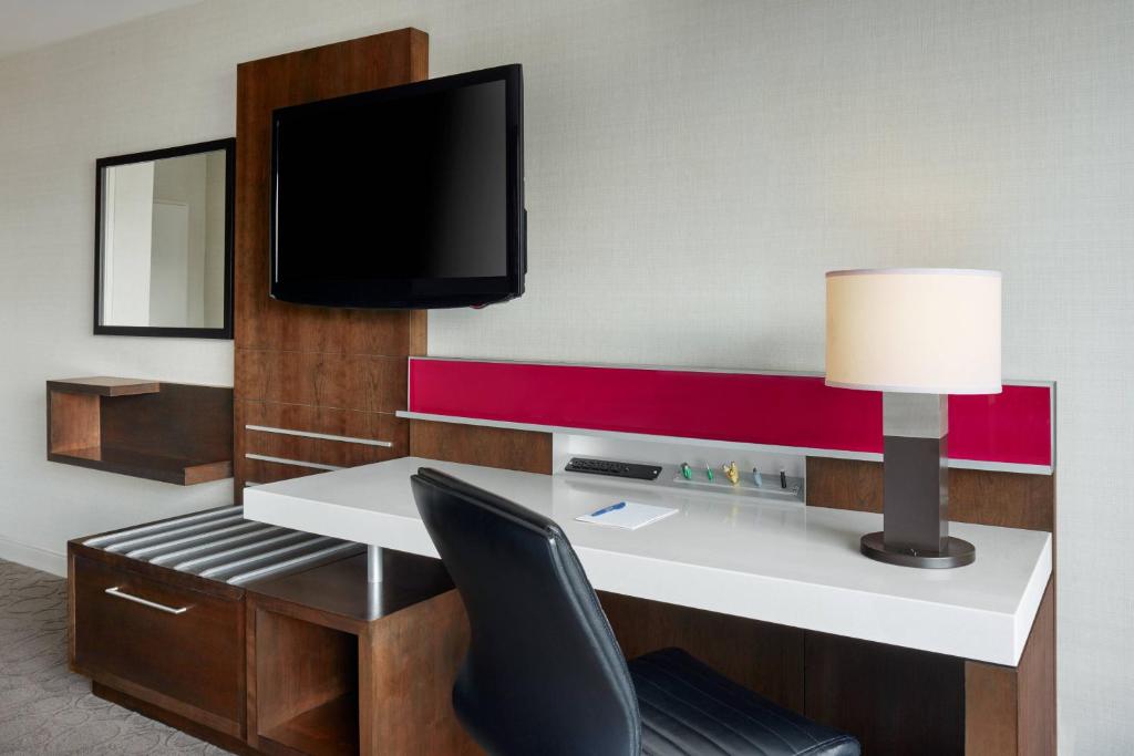 a room with a desk with a tv and a chair at Delta Hotels by Marriott Ottawa City Centre in Ottawa