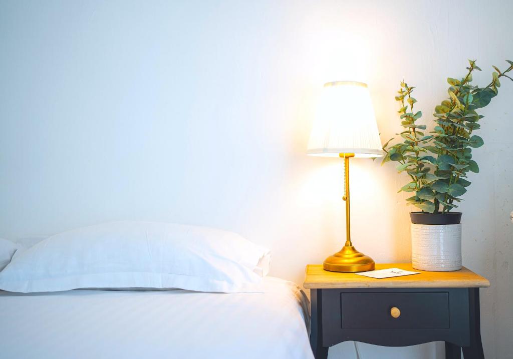 un lit avec une lampe et une installation sur une table de nuit dans l'établissement Élégance Moderne - Calme Absolu - Proche Lac & Parcs, à Vichy