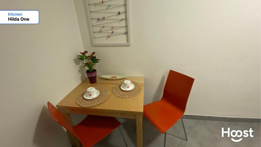 a small table with two chairs and a table with a plate at Hilda: Tranquillo appartamento in centro in Zürich