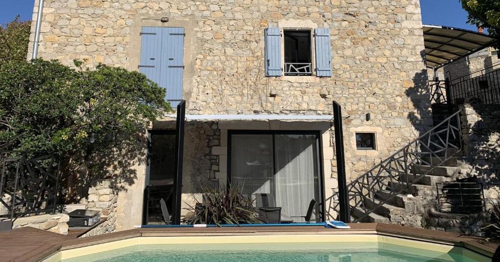 une maison avec piscine devant un immeuble dans l'établissement Le Mas Saint Martin, à Vallon-Pont-dʼArc