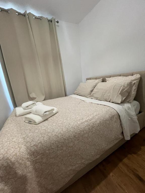 un lit blanc avec deux serviettes dessus dans l'établissement APPARTEMENT AU CŒUR DE MARAIS DANS CENTRE de PARIS, à Paris