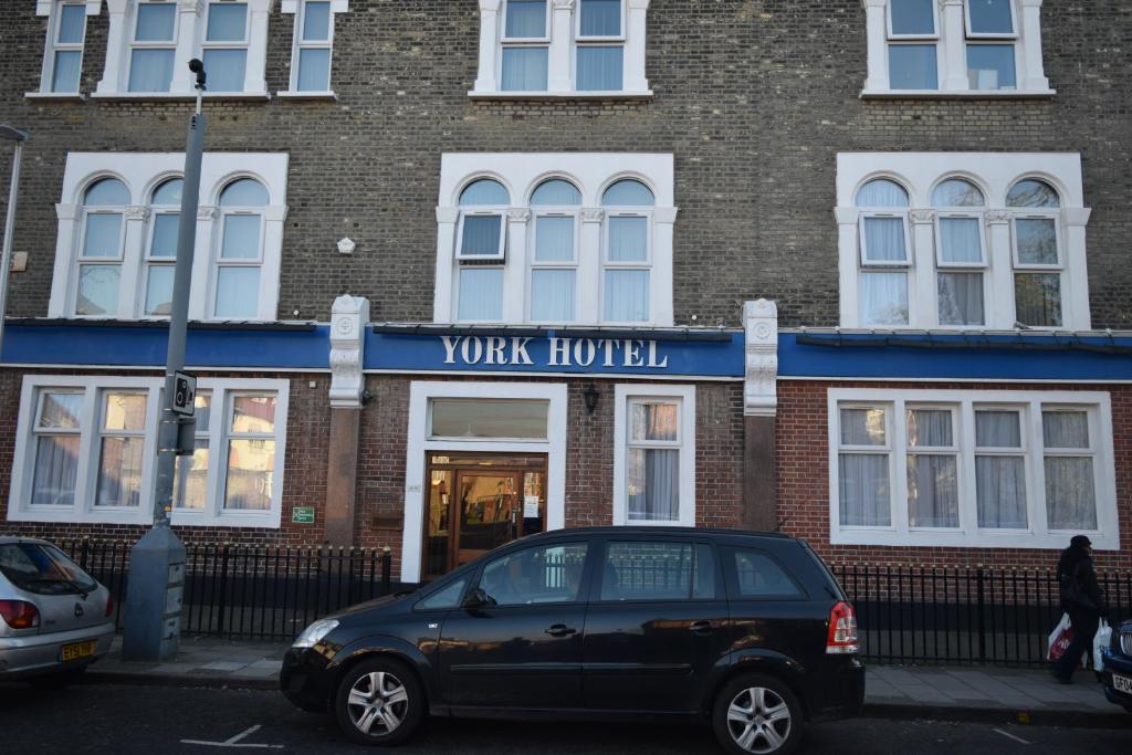 un coche negro estacionado frente a un edificio de ladrillo en York Hotel, en Ilford