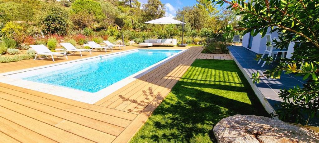 une cour arrière avec une piscine et une terrasse en bois dans l'établissement Villa Alba, 8 pers, piscine chauffée, 5 minutes plage, à Cirendinu