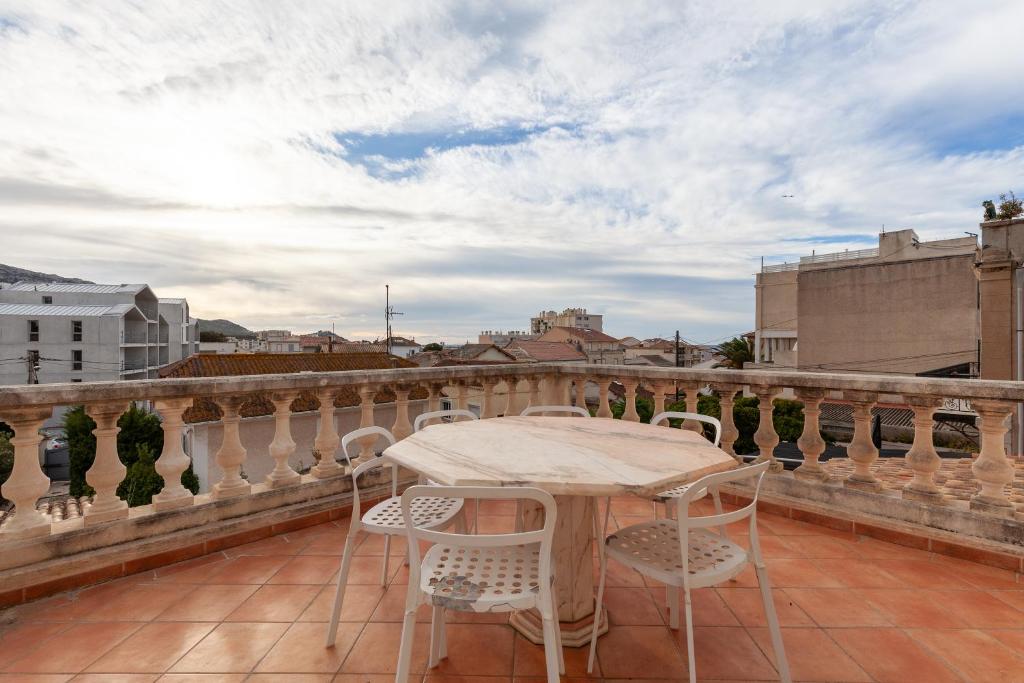 d'un balcon sur le toit avec une table et des chaises. dans l'établissement Appartement - L'Esperance, à Marseille