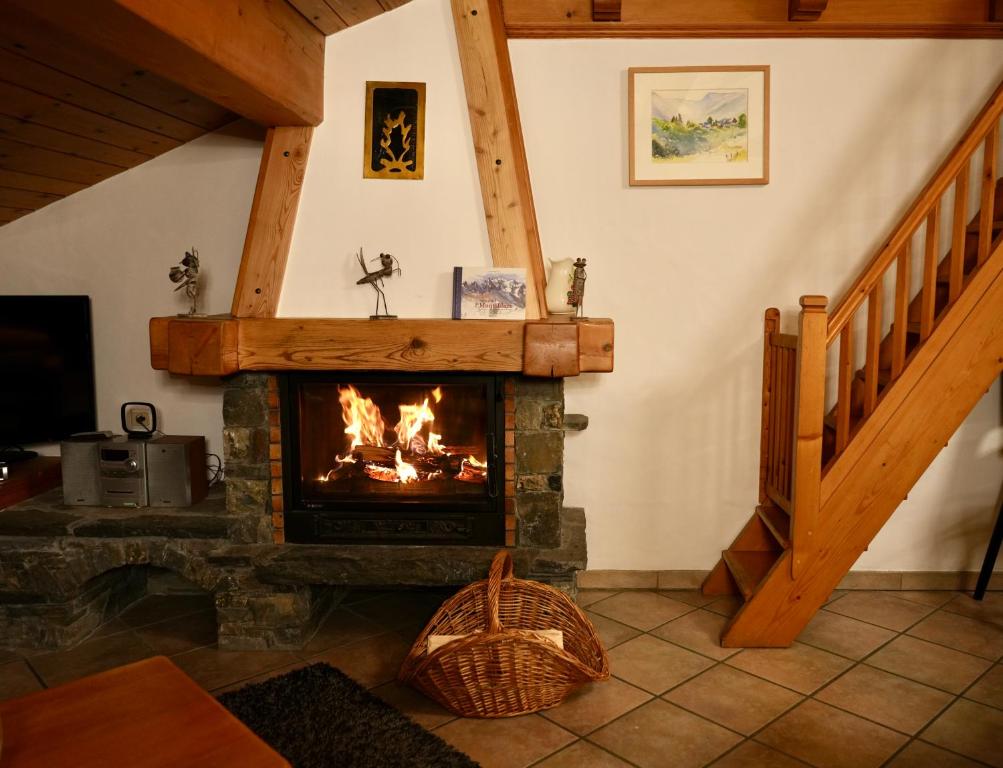 d'un salon avec une cheminée et un escalier. dans l'établissement Chalet Les Barmés, à Champagny-en-Vanoise
