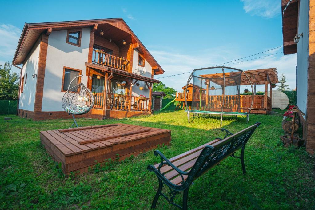 a house with a bench and a playground in the yard at Къщи за гости 'Веринско' in Verinsko