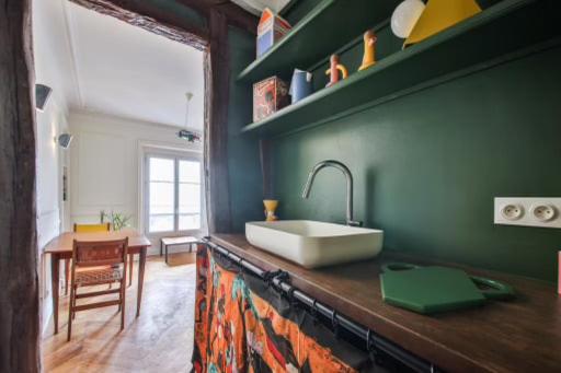 - une cuisine avec un évier et un mur vert dans l'établissement Republique of Paris, à Paris