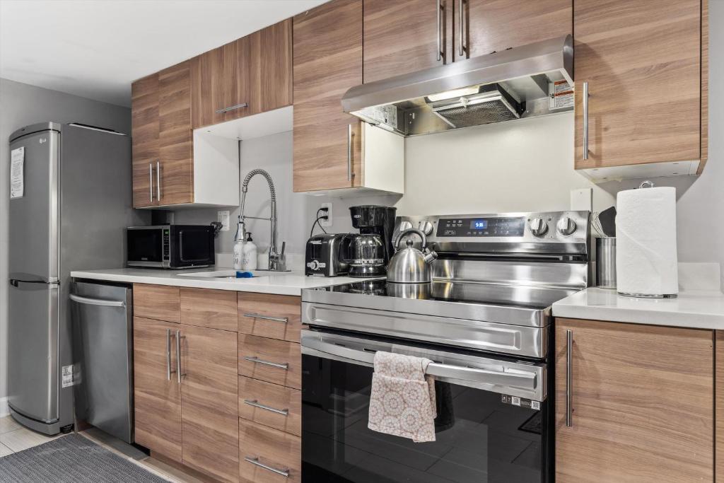 a kitchen with stainless steel appliances and wooden cabinets at Walk to Parks Restaurants Monuments & More in Washington, D.C.