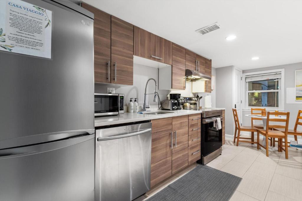 a kitchen with wooden cabinets and a stainless steel refrigerator at Walk to Parks Restaurants Monuments & More in Washington, D.C.