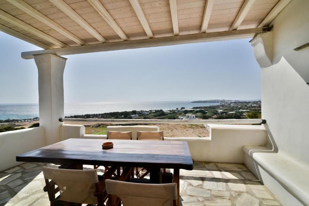 una mesa y sillas en un balcón con vistas al océano en Akrotiraki Villas, en Tinos
