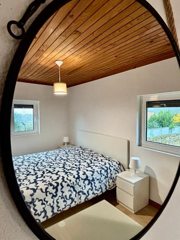 a bedroom with a bed and a round mirror at Casa da Laurinha in Arcos de Valdevez