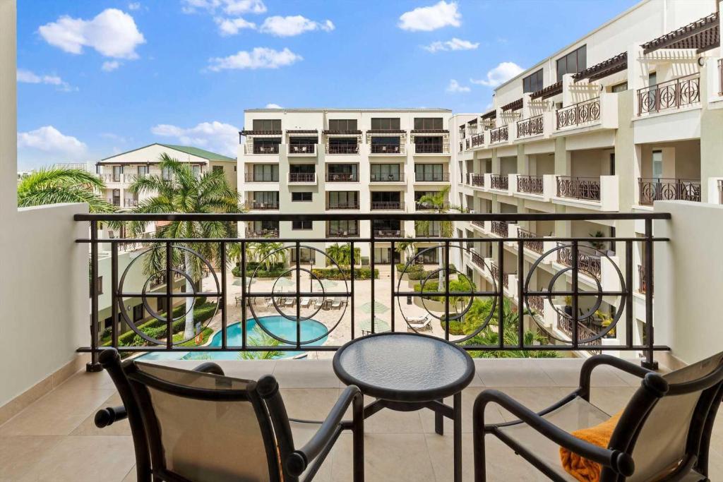 balcón con mesa, sillas y vistas a la piscina en PC412 - Pool View - 1BR Perfect for a couple or Family - Close to Palm Beach - 1BR, en Palm-Eagle Beach
