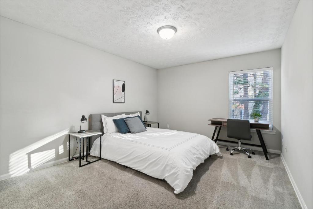 a white bedroom with a bed and a desk at Halsten At Vinings 2515 Comfy 1 Bed 1 Bath in Atlanta